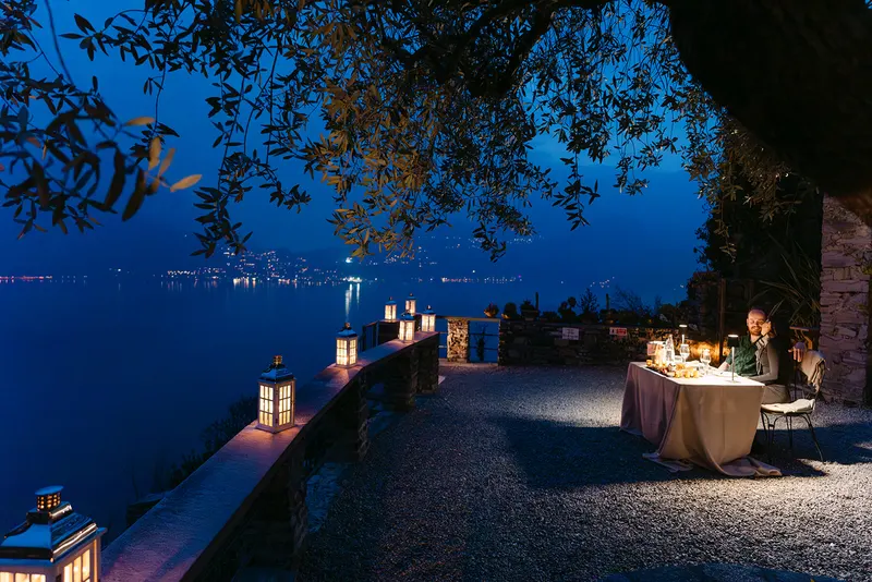 Nate and Angie sharing a candlelit dinner overlooking a mountain lake at night
